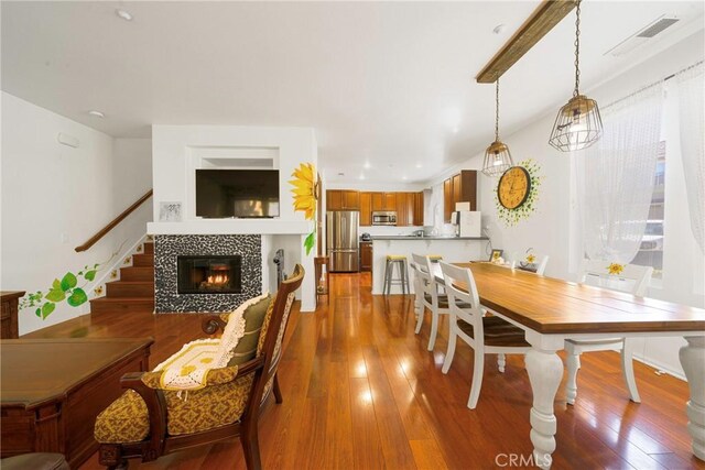 dining area with a tiled fireplace and hardwood / wood-style flooring