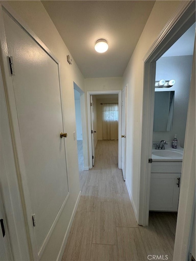 hall featuring light hardwood / wood-style floors and sink