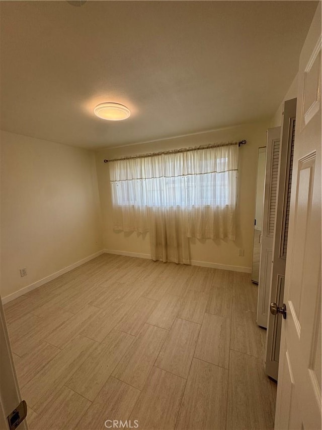 spare room featuring a wealth of natural light and light hardwood / wood-style flooring