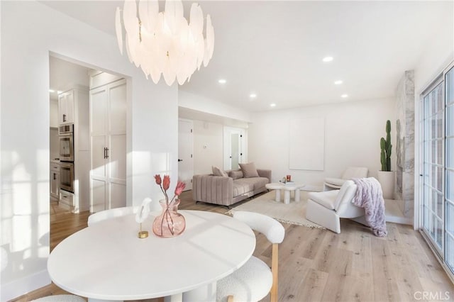 dining area featuring light hardwood / wood-style floors and a notable chandelier