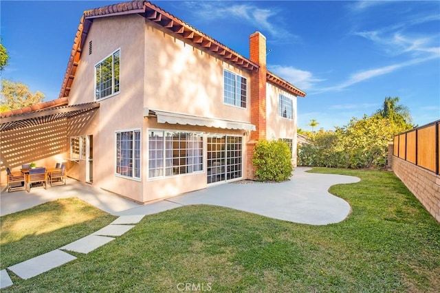 rear view of property with a lawn and a patio area