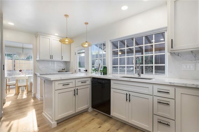 kitchen featuring white cabinets, black dishwasher, a healthy amount of sunlight, and sink