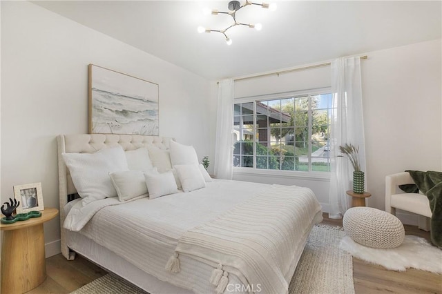 bedroom with a chandelier and hardwood / wood-style floors