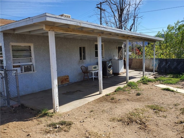 view of home's exterior featuring washing machine and dryer, cooling unit, and a patio