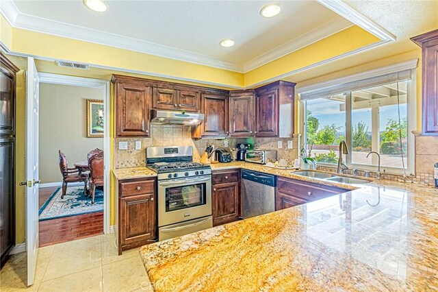 kitchen with sink, light tile patterned floors, ornamental molding, and appliances with stainless steel finishes