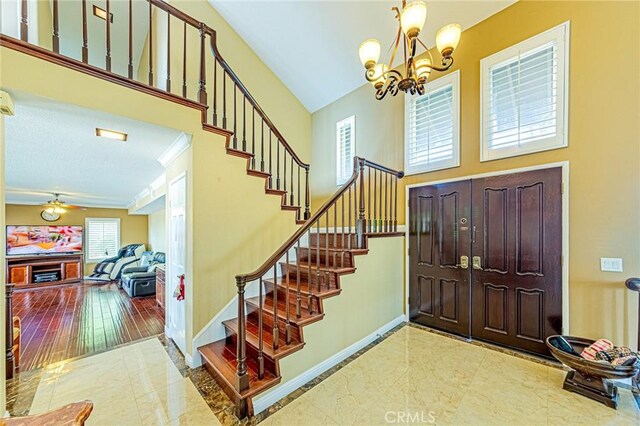 entryway with ornamental molding and an inviting chandelier