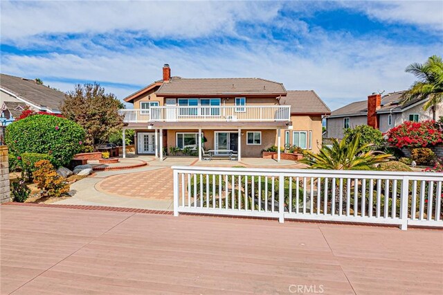 view of front of property with a balcony and a patio area