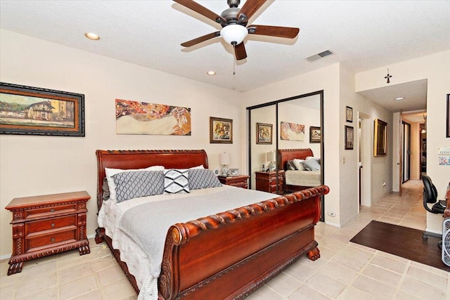 tiled bedroom with ceiling fan and a closet