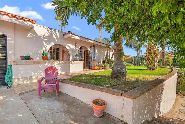 view of front of house with a front lawn and a patio