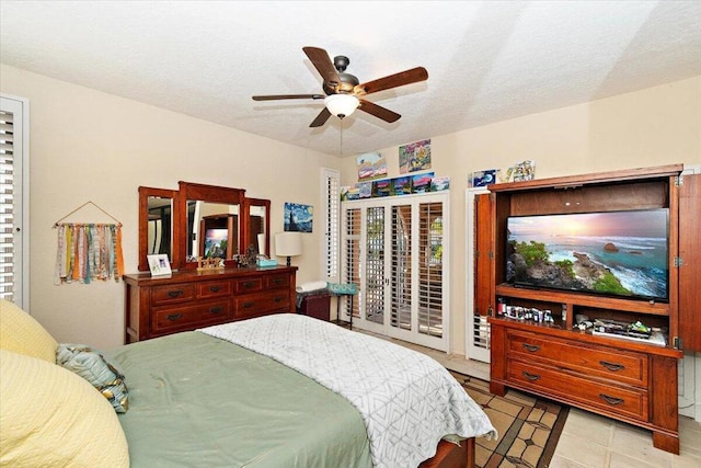 bedroom featuring ceiling fan, access to exterior, a textured ceiling, and light tile patterned flooring