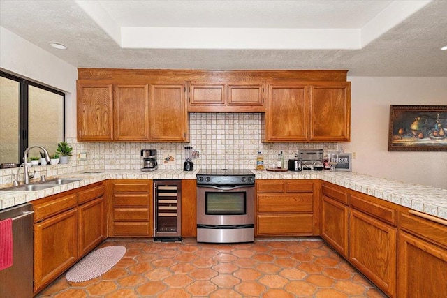 kitchen featuring stainless steel appliances, wine cooler, tasteful backsplash, and sink