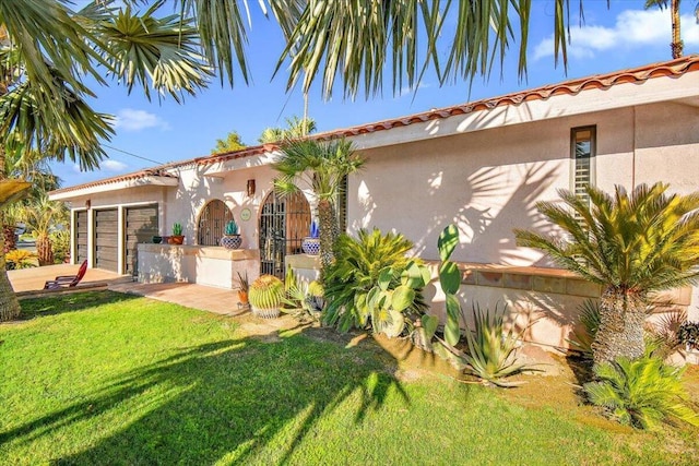 mediterranean / spanish-style house featuring a garage and a front lawn