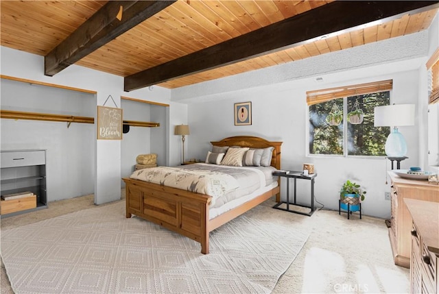 carpeted bedroom with beamed ceiling and wood ceiling