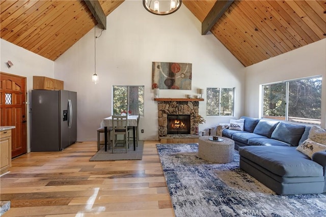 living room featuring a fireplace, light hardwood / wood-style floors, beam ceiling, and high vaulted ceiling