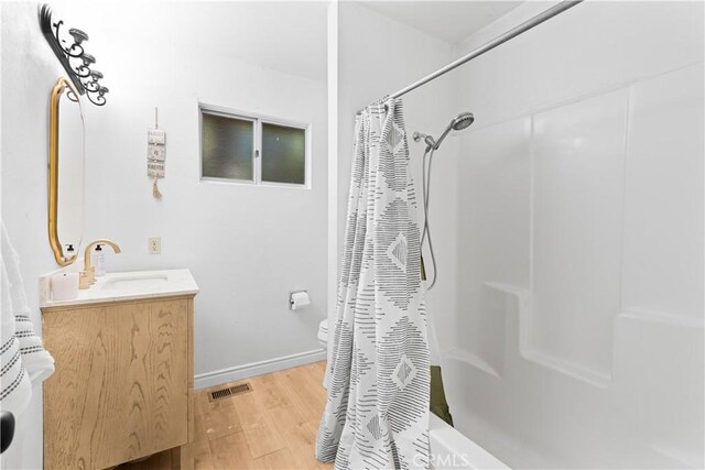 467 Cimarron Ln, Lake Arrowhead, CA 92352 - bathroom featuring wood finished floors, vanity, shower / bath combination with curtain, and baseboards