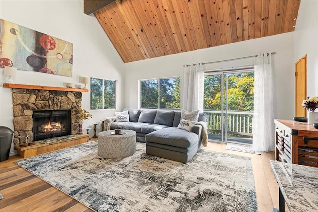 living room featuring beam ceiling, high vaulted ceiling, hardwood / wood-style floors, a fireplace, and wood ceiling