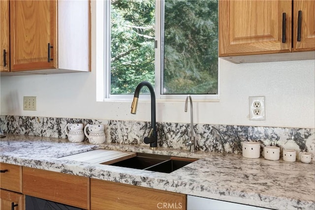 kitchen featuring light stone countertops and sink