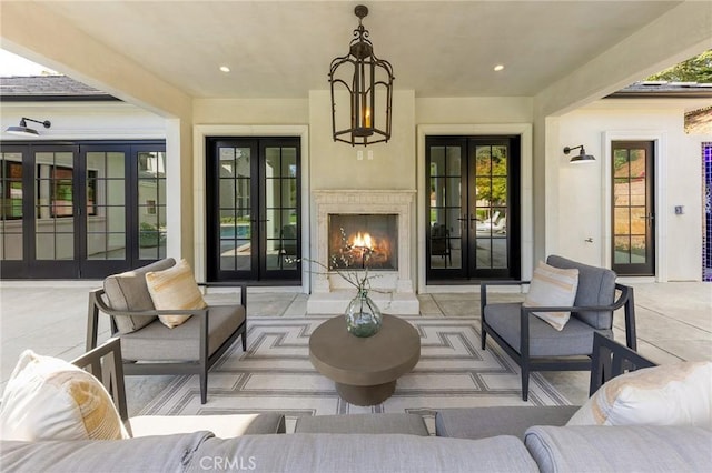 view of patio / terrace featuring an outdoor living space with a fireplace and french doors