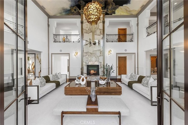 living room with carpet floors, a fireplace, and a towering ceiling