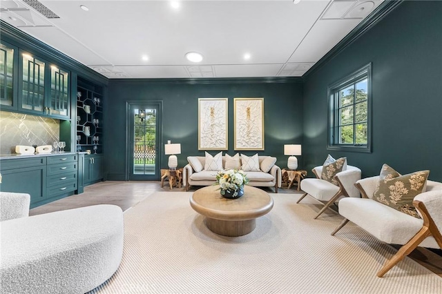 sitting room with indoor bar and crown molding