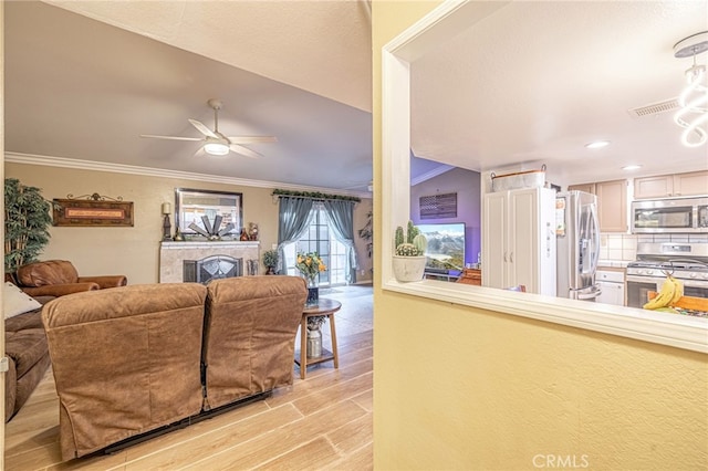 living room featuring light hardwood / wood-style flooring, ornamental molding, and ceiling fan