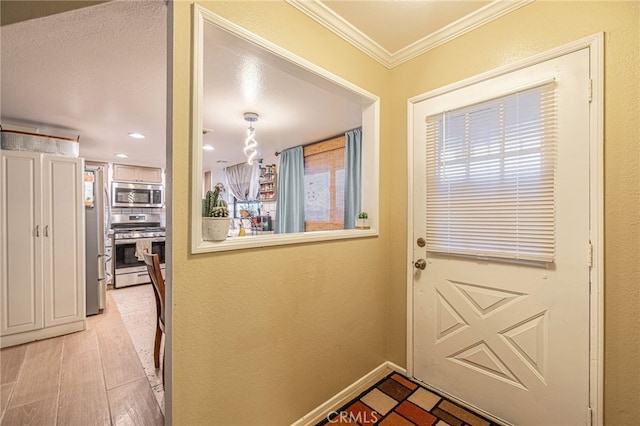 entryway with ornamental molding and light hardwood / wood-style floors