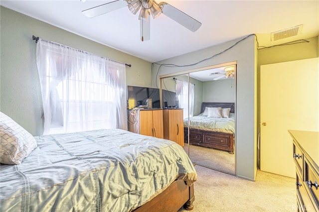 carpeted bedroom featuring multiple windows, ceiling fan, and a closet