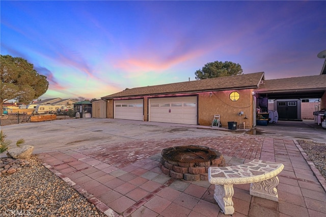 view of garage at dusk