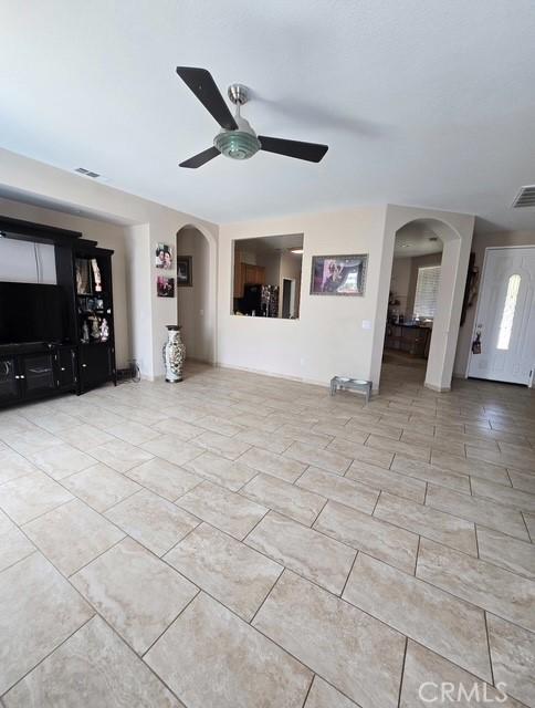 29822 Cool Meadow Dr, Menifee, CA 92584 - unfurnished living room with arched walkways and ceiling fan