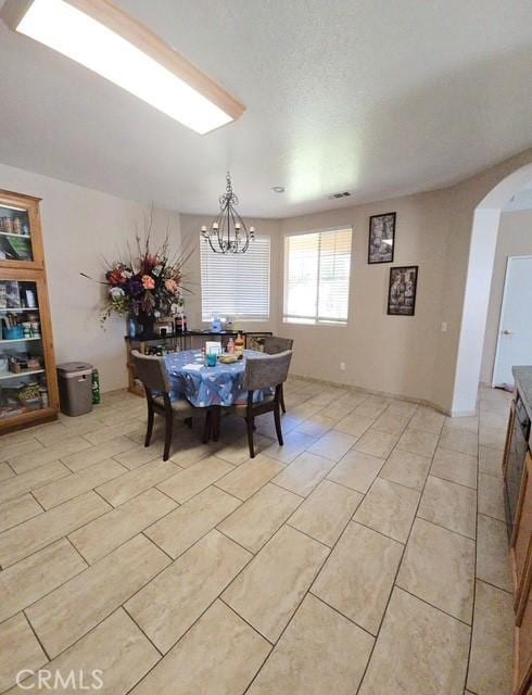 29822 Cool Meadow Dr, Menifee, CA 92584 - dining area with arched walkways, a chandelier, and light tile patterned flooring