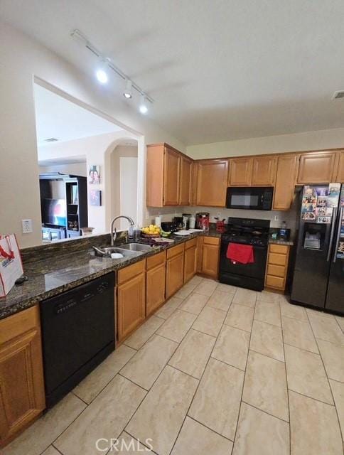 29822 Cool Meadow Dr, Menifee, CA 92584 - kitchen with black appliances, light tile patterned floors, arched walkways, dark stone counters, and track lighting