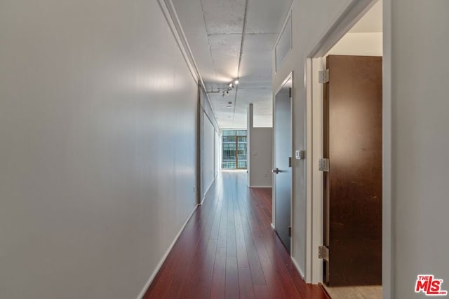 corridor with hardwood / wood-style floors and crown molding