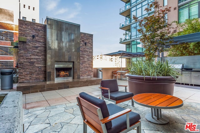 view of patio with a fireplace and an outdoor bar