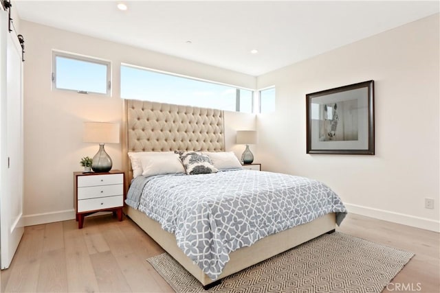 bedroom featuring light hardwood / wood-style flooring and multiple windows