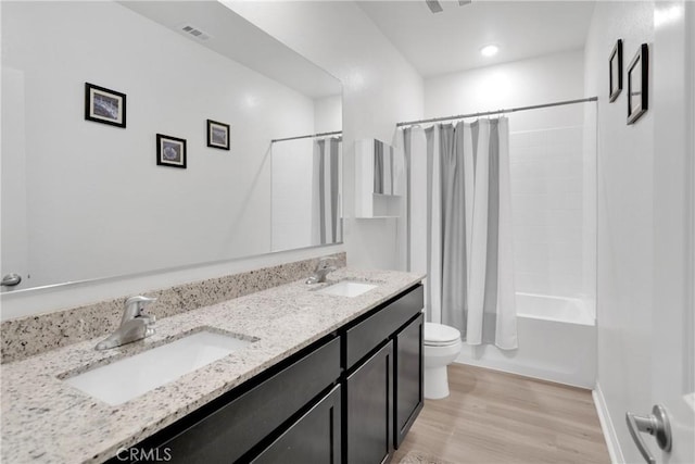 full bathroom featuring hardwood / wood-style floors, vanity, toilet, and shower / bath combo with shower curtain