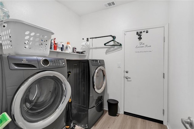 washroom featuring light hardwood / wood-style floors and washing machine and clothes dryer