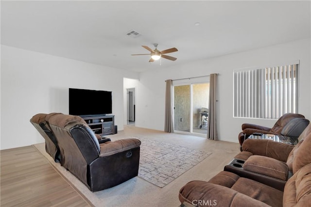 living room with light hardwood / wood-style flooring and ceiling fan