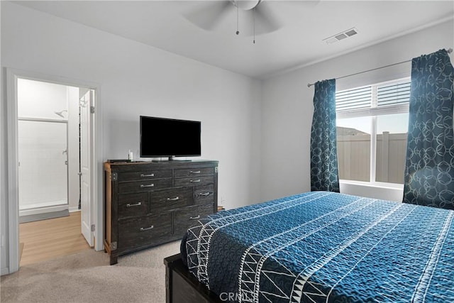 bedroom with light carpet, connected bathroom, and ceiling fan