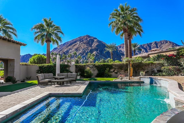 view of swimming pool with a mountain view, pool water feature, and a patio