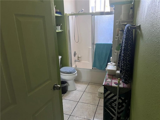 bathroom with tile patterned flooring, bathtub / shower combination, and toilet