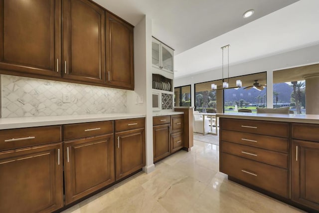 kitchen featuring backsplash, dark brown cabinets, and pendant lighting