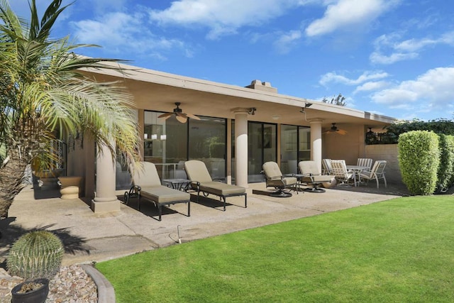 back of property with ceiling fan, a patio area, and a yard