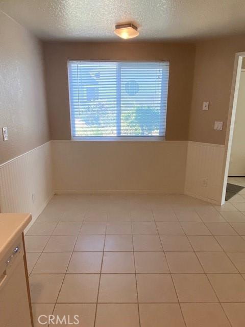 spare room featuring light tile patterned floors and a textured ceiling