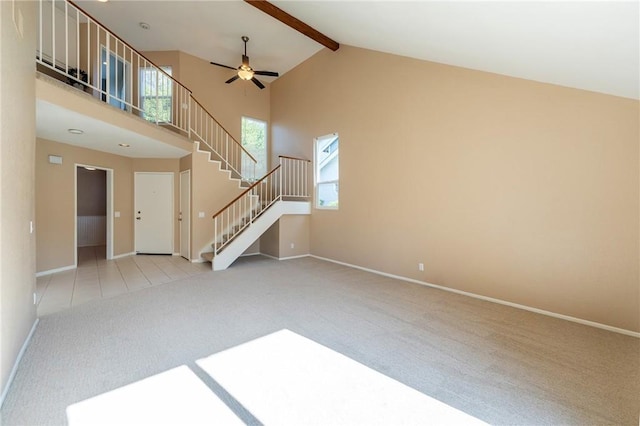 unfurnished living room featuring beam ceiling, light carpet, high vaulted ceiling, and ceiling fan