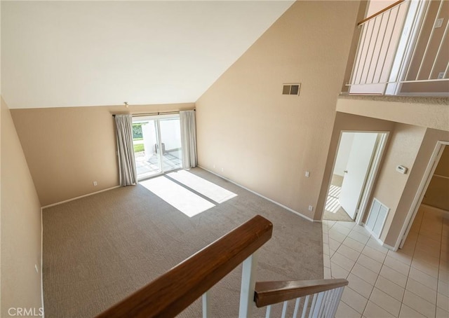 carpeted empty room featuring vaulted ceiling