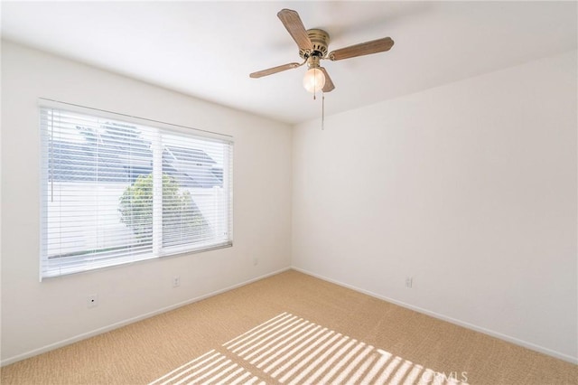 empty room with ceiling fan and light carpet