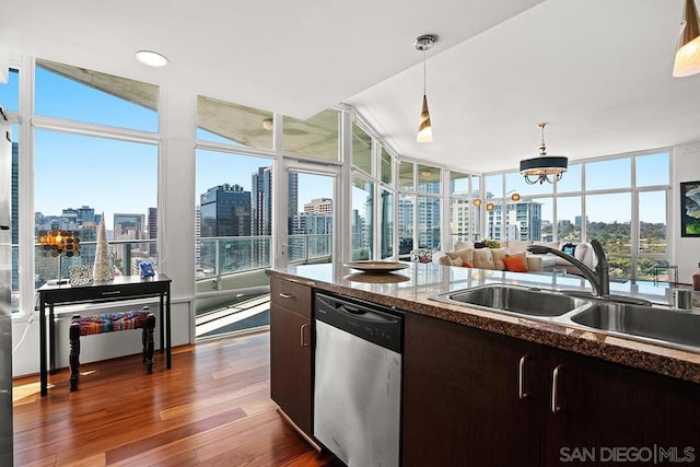 kitchen with dark hardwood / wood-style flooring, stainless steel dishwasher, dark brown cabinetry, sink, and hanging light fixtures