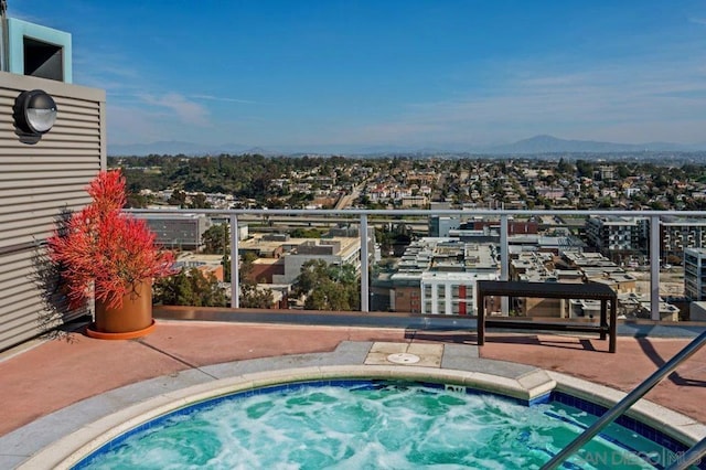 view of swimming pool with a mountain view and a hot tub