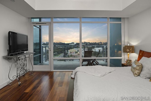 bedroom featuring floor to ceiling windows and dark wood-type flooring