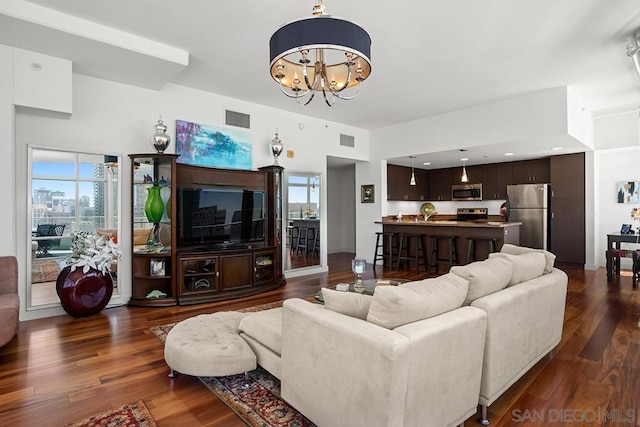 living room with dark hardwood / wood-style floors and a chandelier